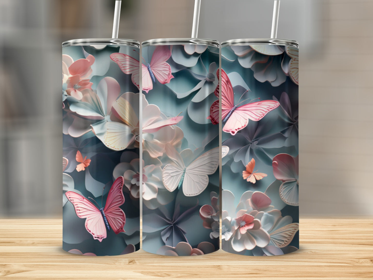 Three tumblers with a pastel butterfly and floral design on a wooden surface.