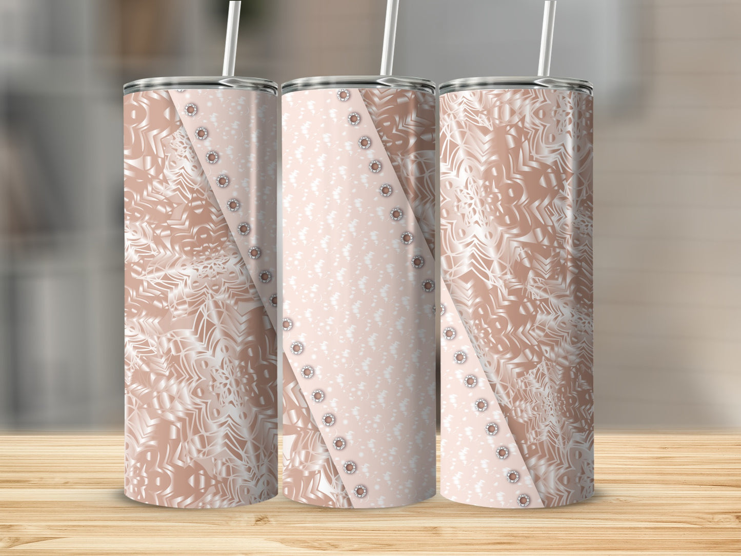 Three rose gold tumblers with white snowflake and dotted patterns on a wooden surface.