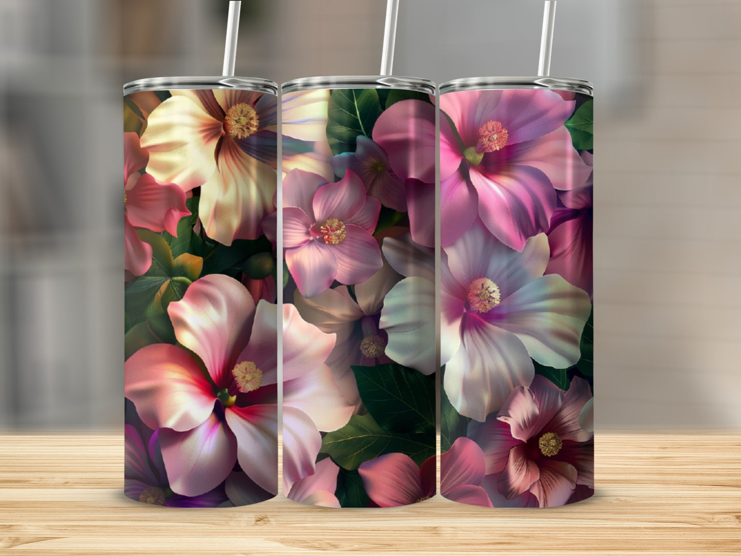 Three floral tumblers with hibiscus flowers on a wooden surface.