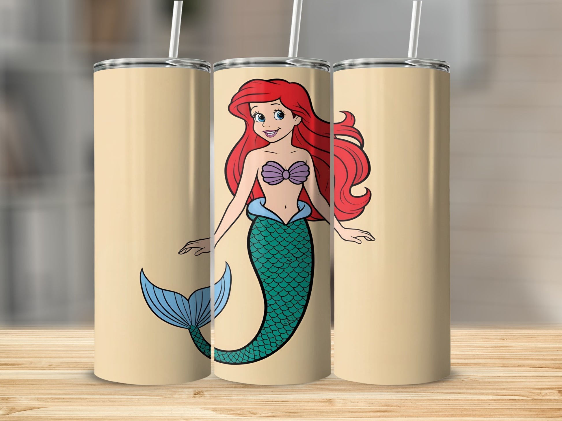 Ariel the mermaid on a tan tumbler with a straw.