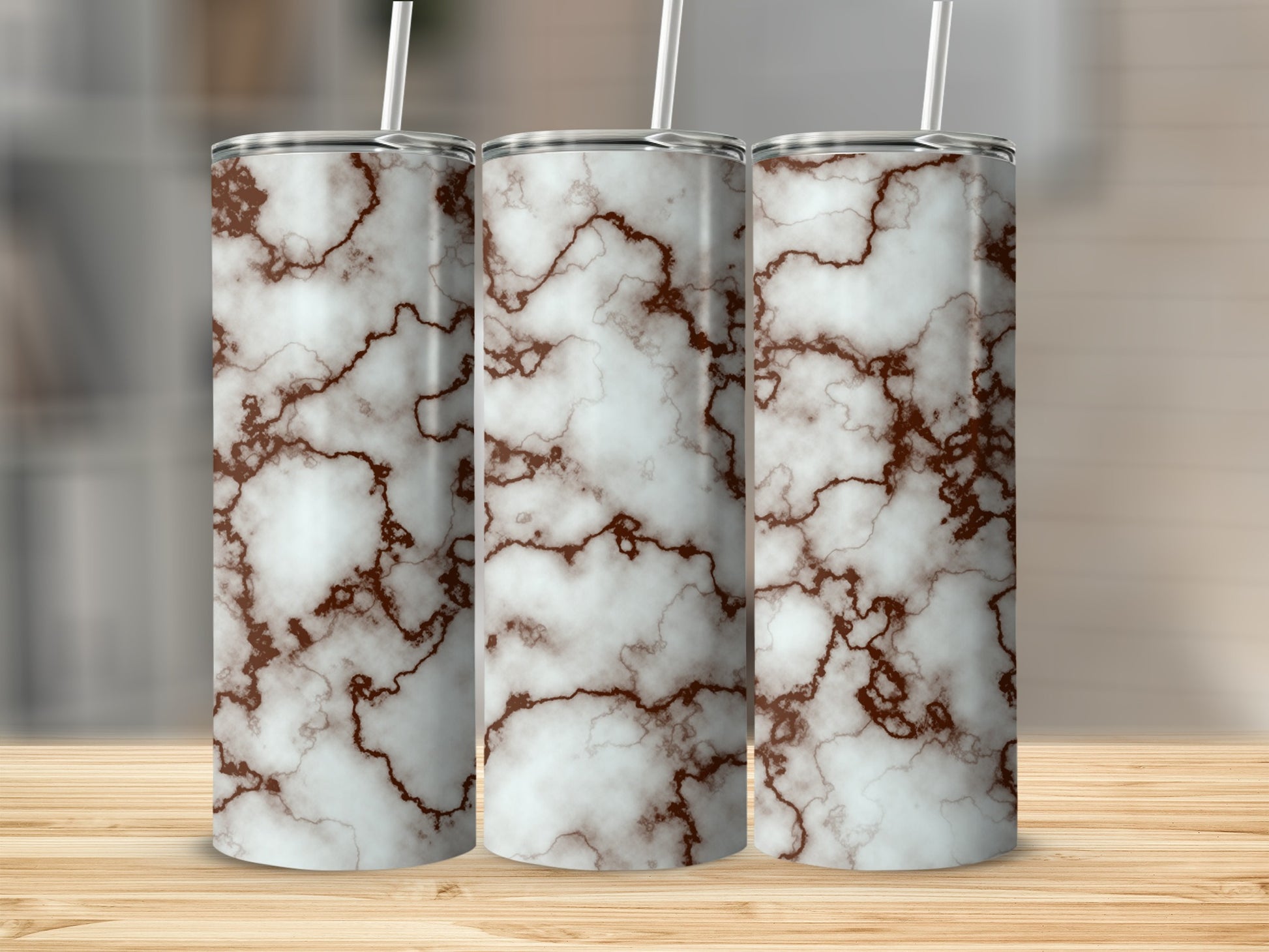 Three tall tumblers with a white and brown marble pattern, each with a straw.