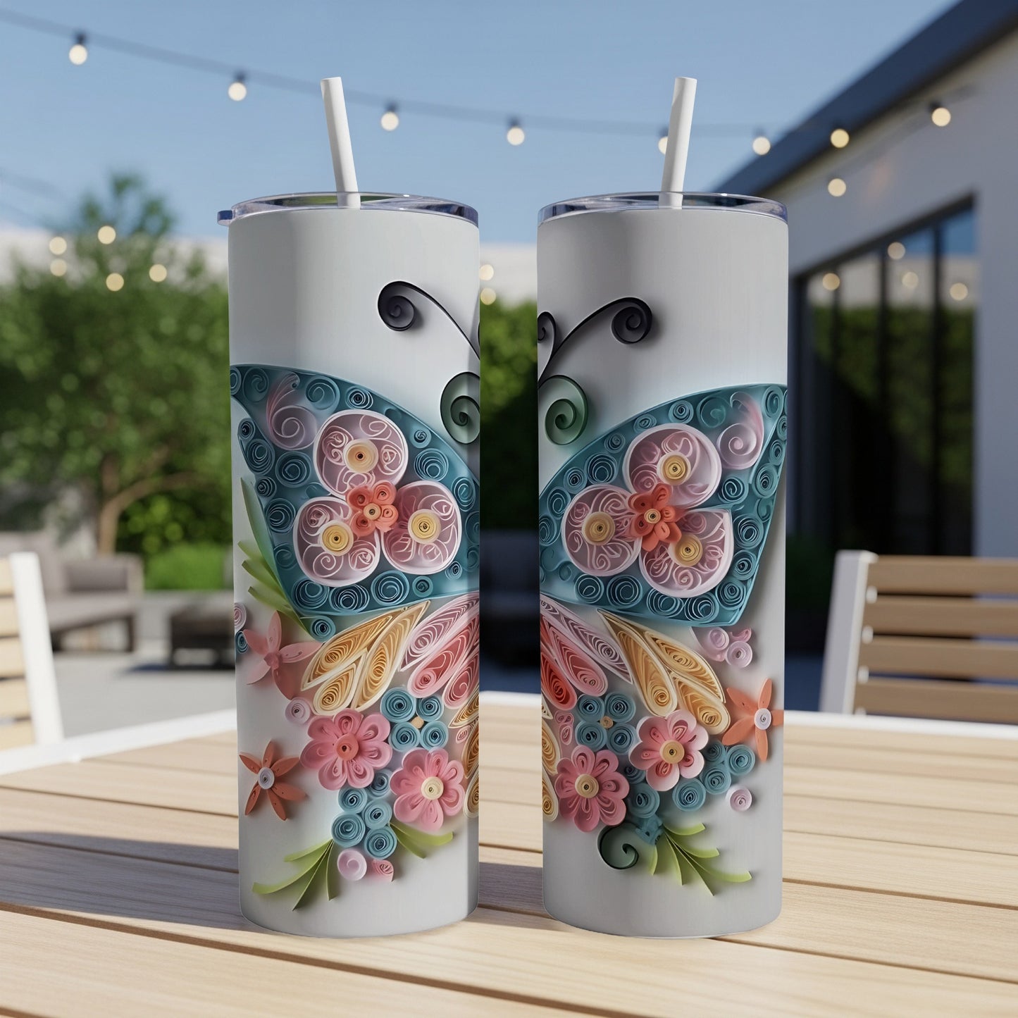 Two white tumblers with a quilled butterfly and floral design, each with a straw.