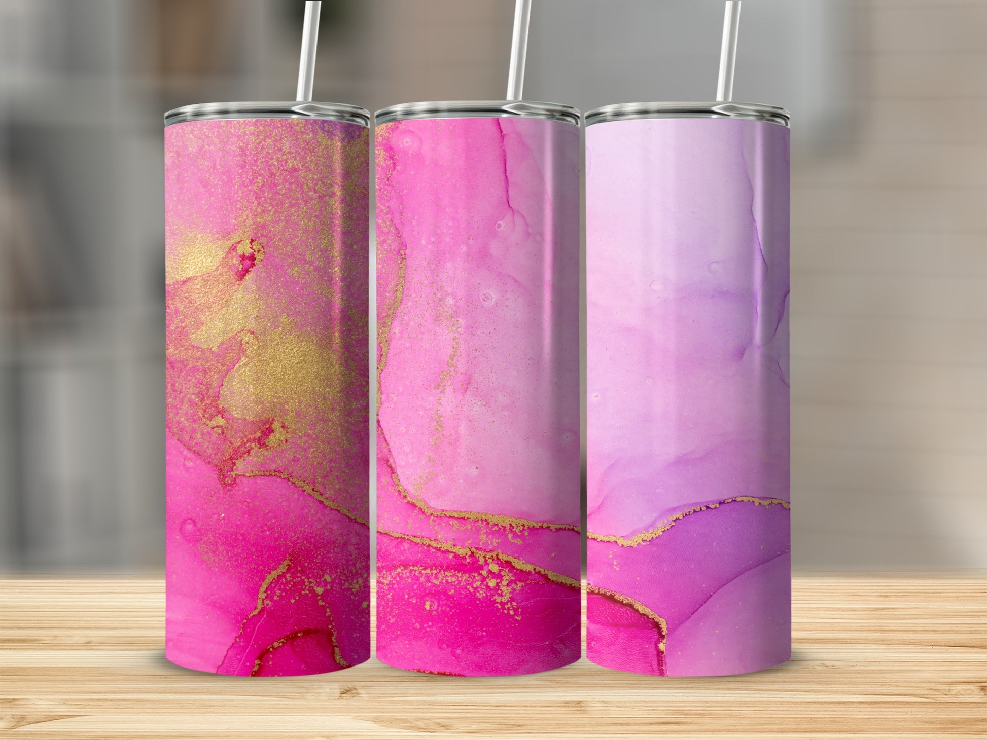 Three tumblers with pink and purple watercolor designs and gold accents.