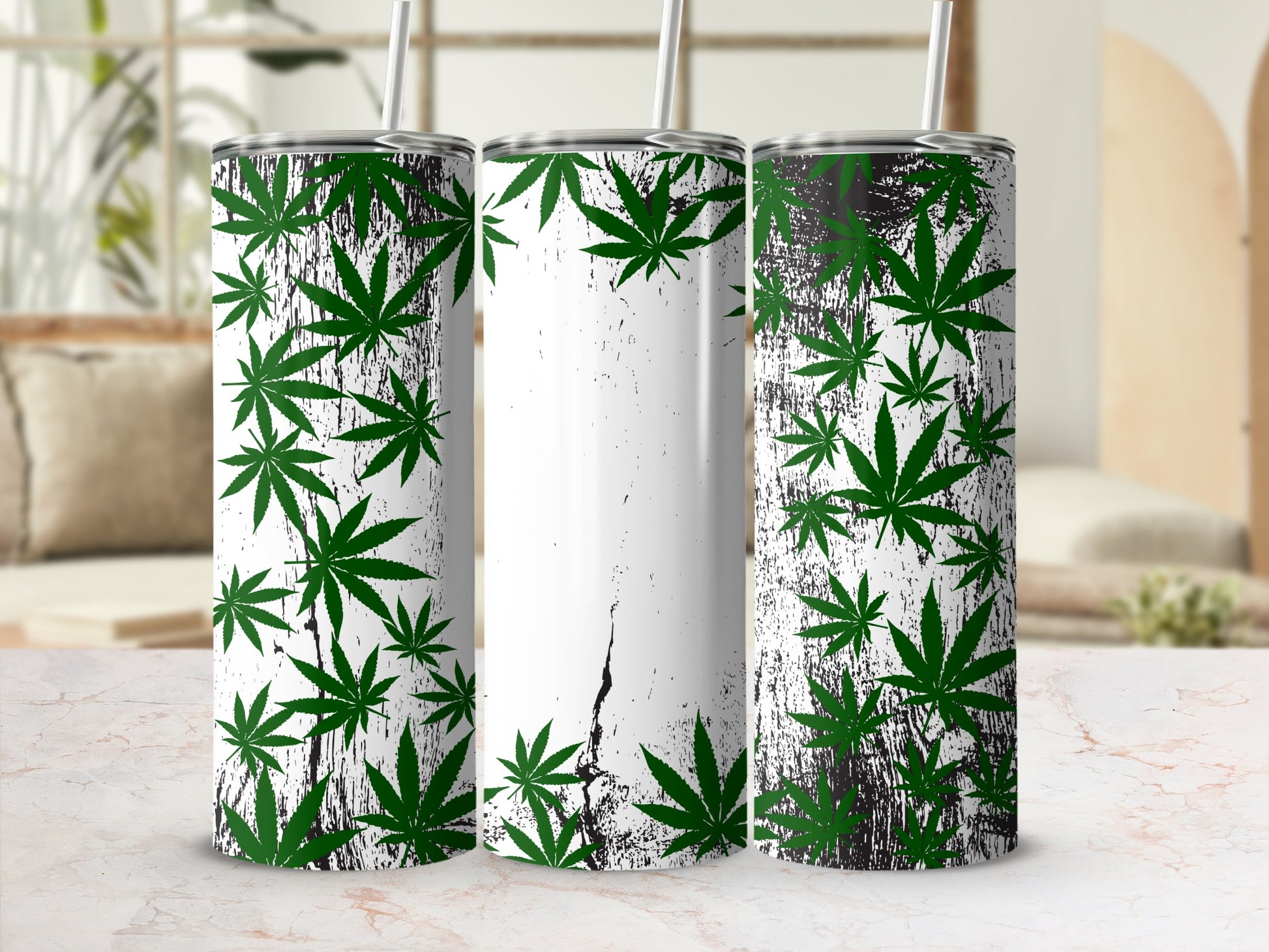Green marijuana leaves scattered across three white and black distressed tumblers.