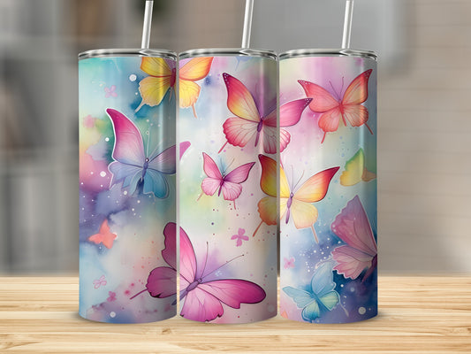 Three tumblers with colorful watercolor butterfly designs on a wooden surface.