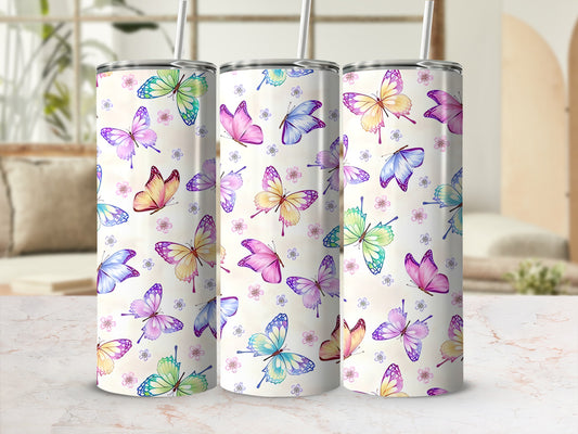 Three tumblers with pastel butterfly designs on a marble surface.