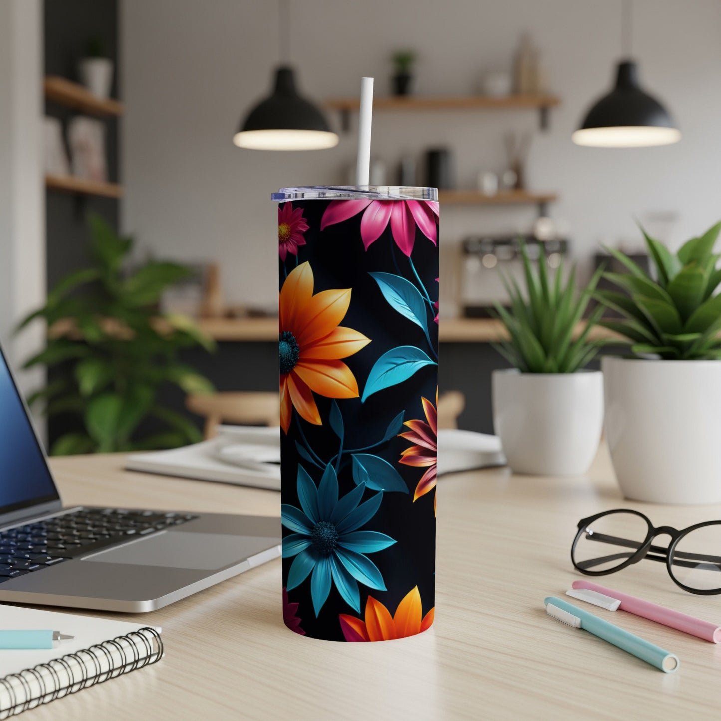 Black tumbler with vibrant orange and teal floral design and white straw.