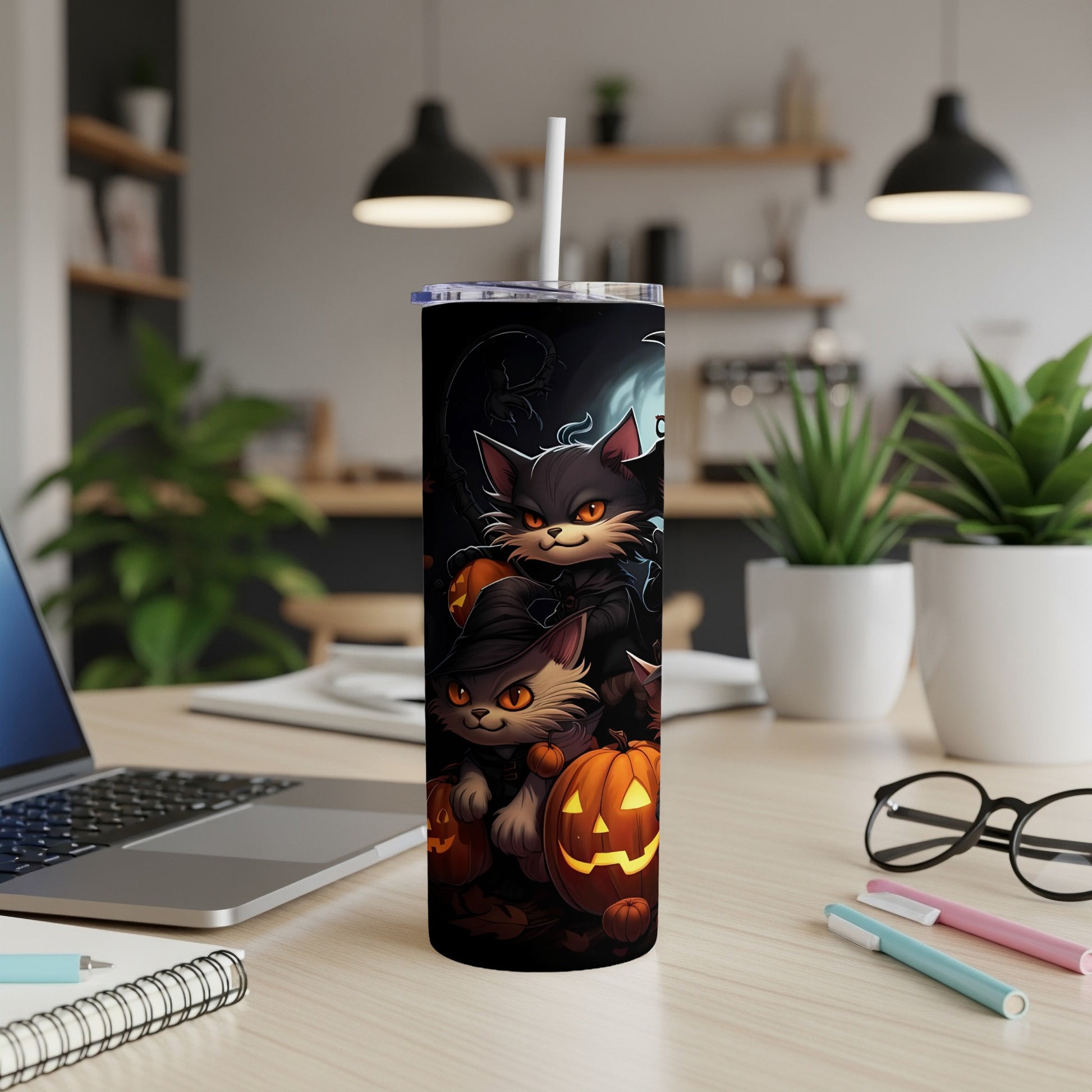 Tumbler featuring cartoon cats and jack-o'-lanterns, presented on a desk.