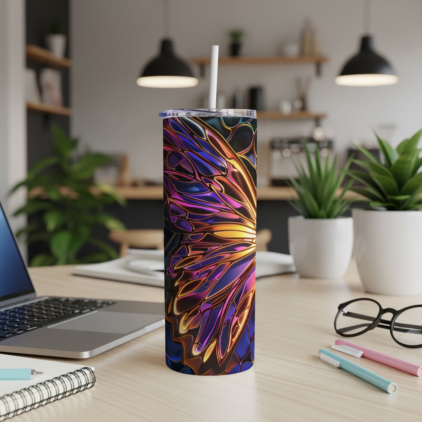 Tumbler with iridescent butterfly wing design on a desk.