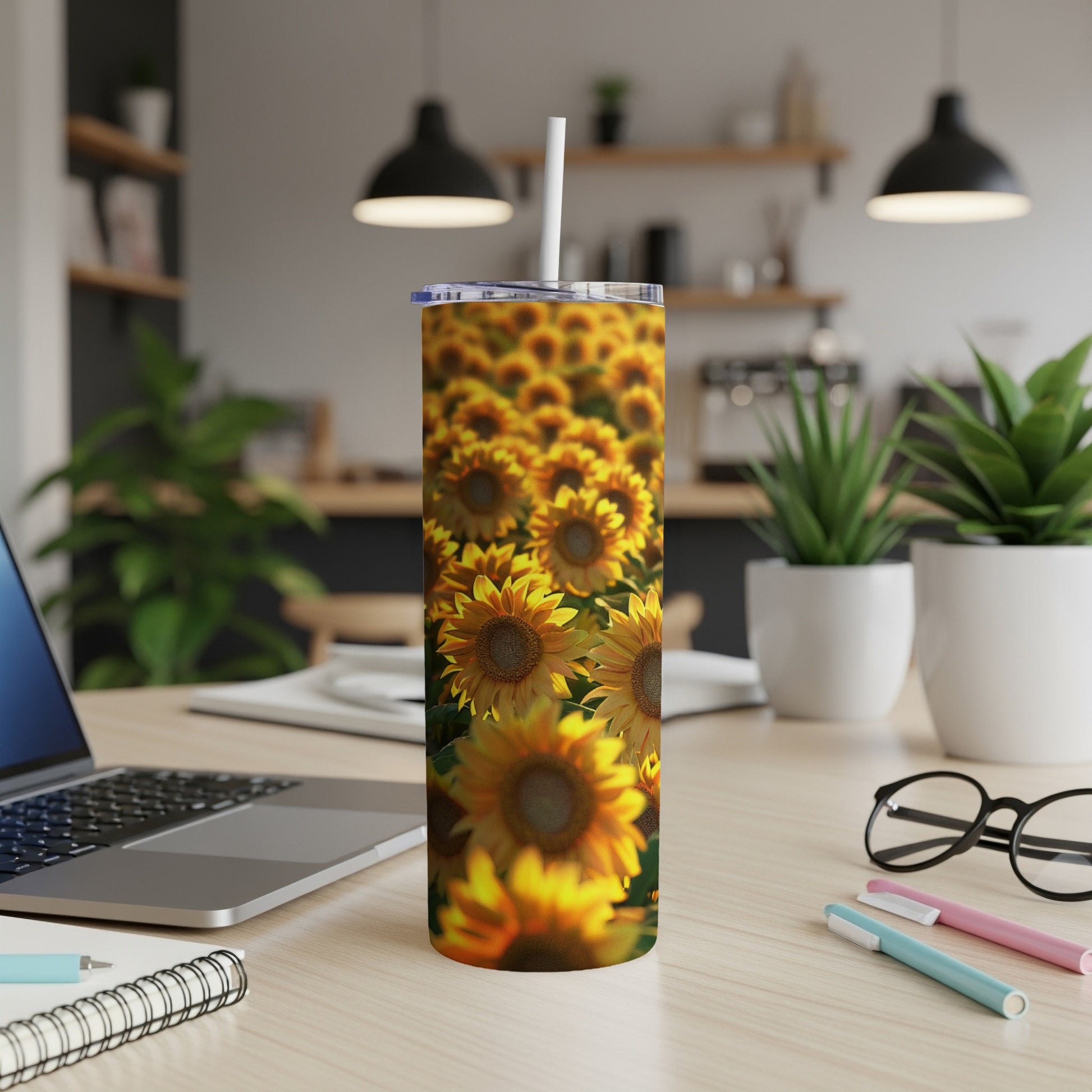 Sunflower pattern on a white tumbler with a straw, placed on a desk.