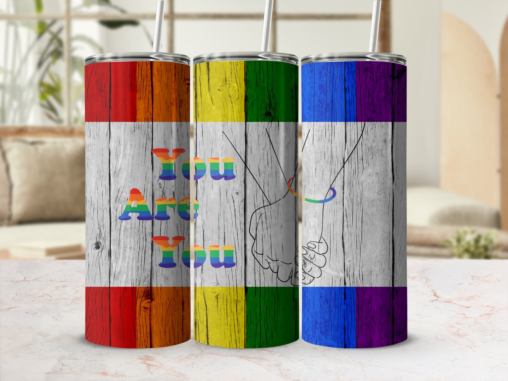 Three rainbow flag tumblers with "You Are You" text and clasped hands.