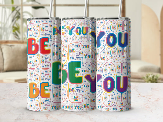 Three tumblers with a colorful "BE YOU" pattern on a marble surface.