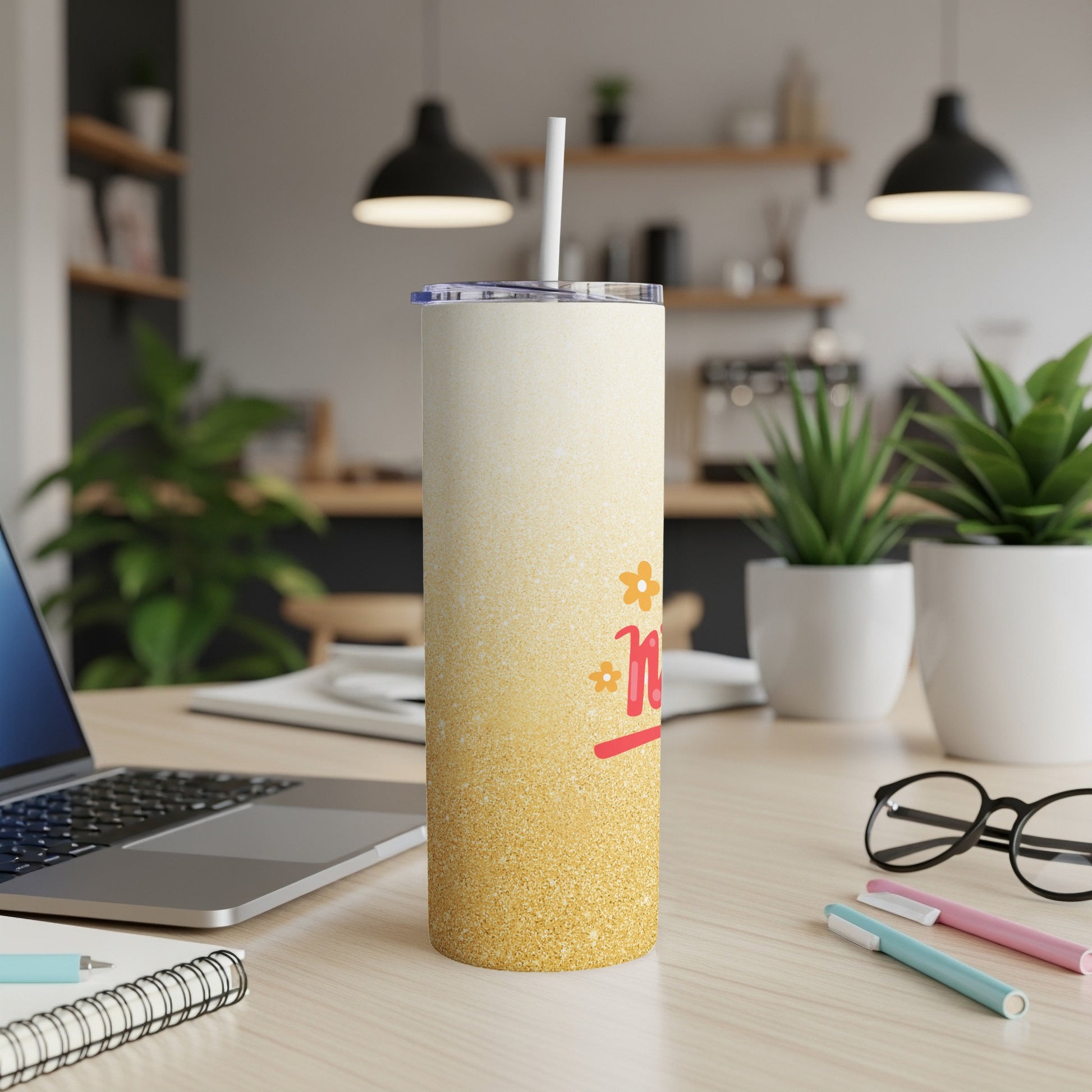 Sparkling gradient tumbler with "Mom" text on a desk with a laptop.
