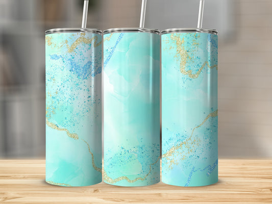 Three teal and gold glitter tumblers with straws on a wooden surface.