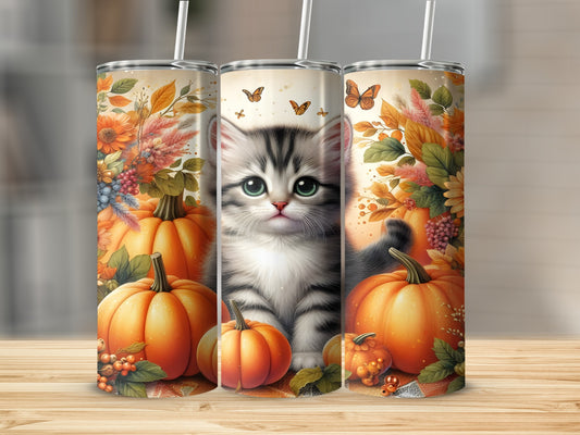 Gray kitten with pumpkins and fall foliage on a tumbler.