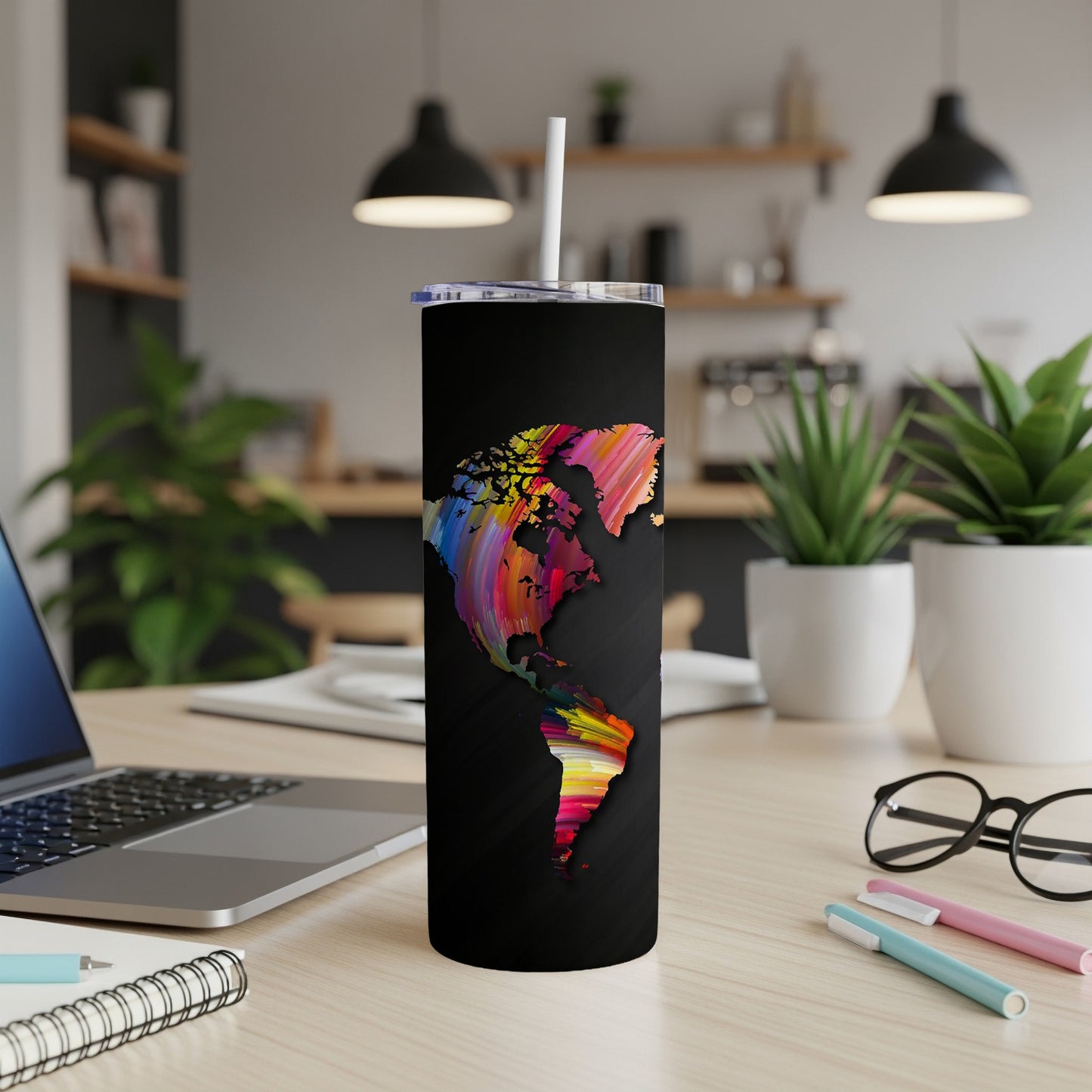 Black tumbler with colorful abstract map of the Americas design and white straw.