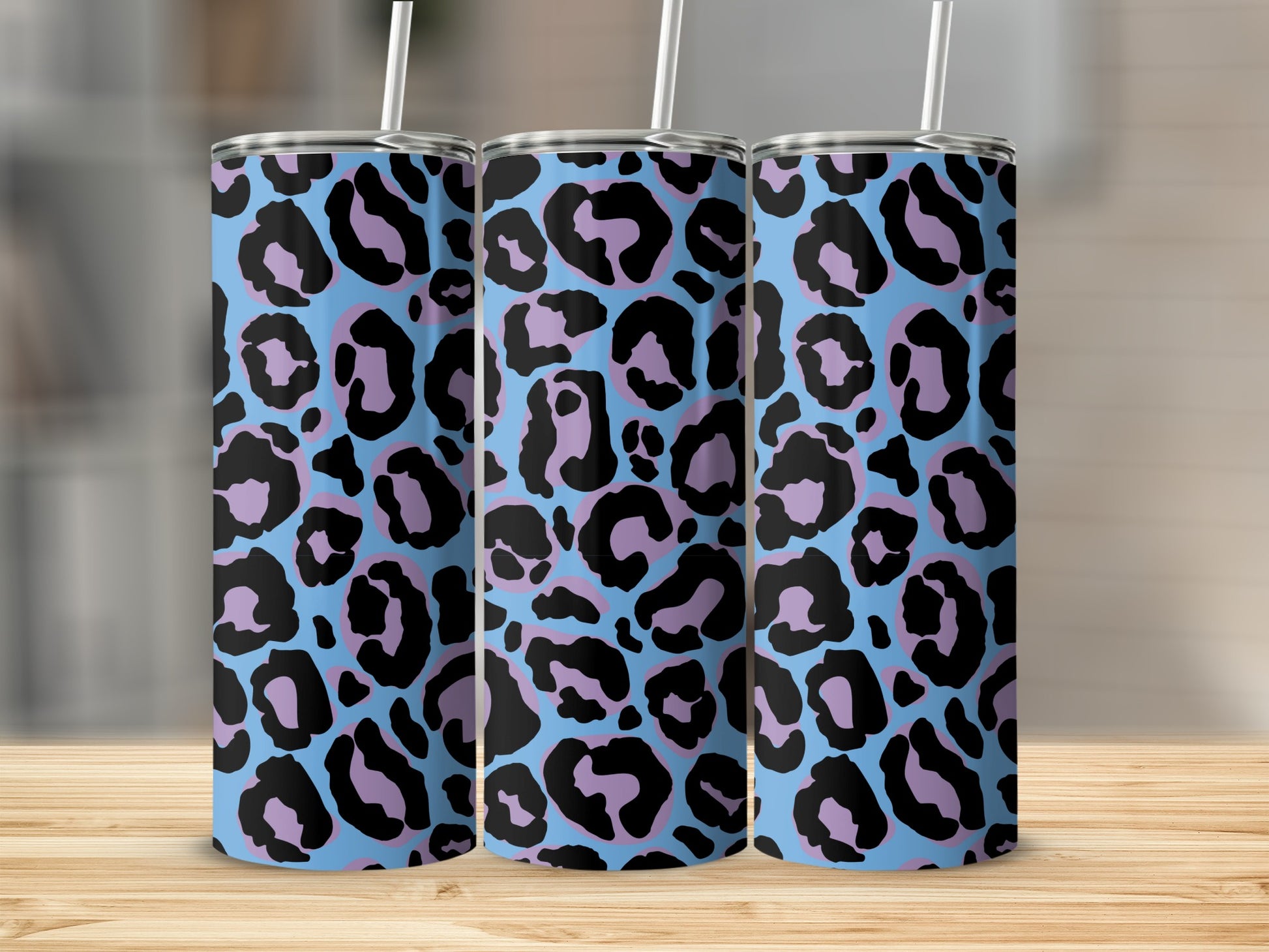 Three tumblers with a light blue base and a black and purple leopard print pattern.