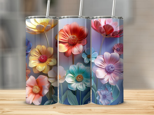 Three colorful floral tumblers with straw on a wooden surface.