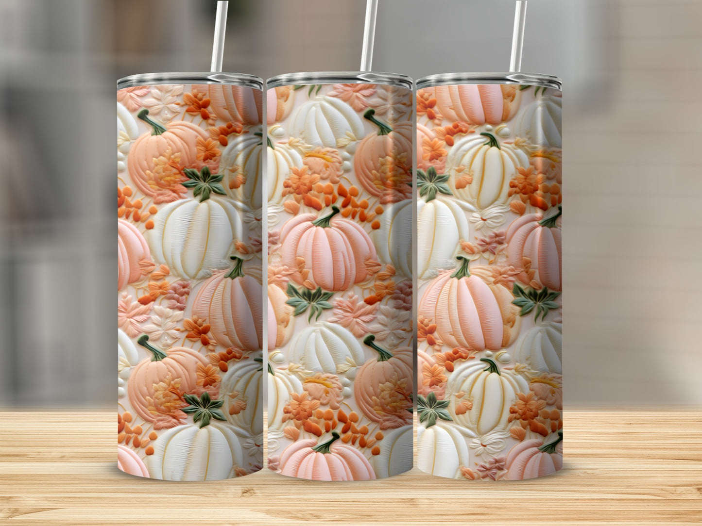 Three tumblers with a pattern of embossed pumpkins and fall leaves.