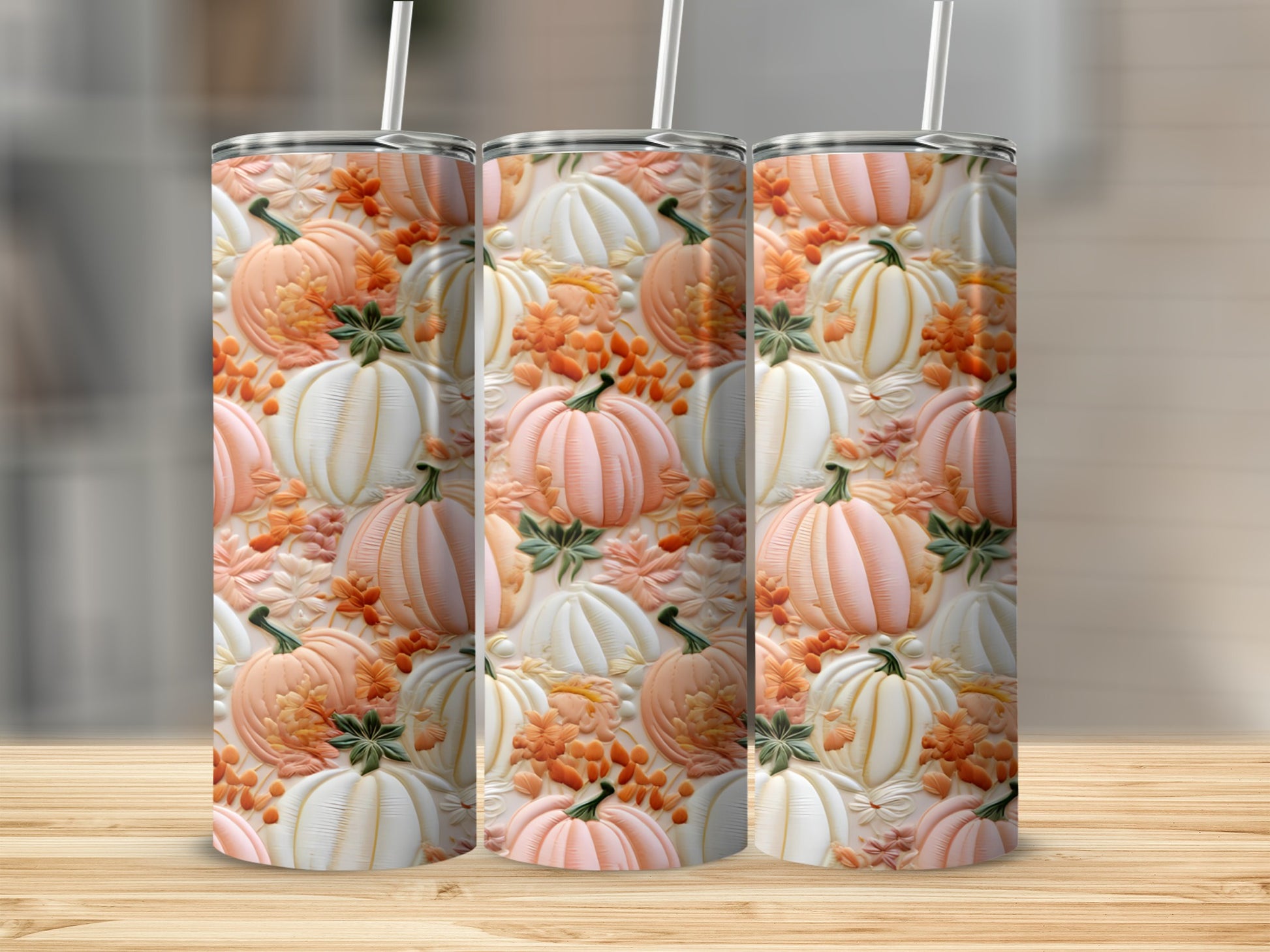 Three tumblers with a pattern of embossed pumpkins and fall leaves.