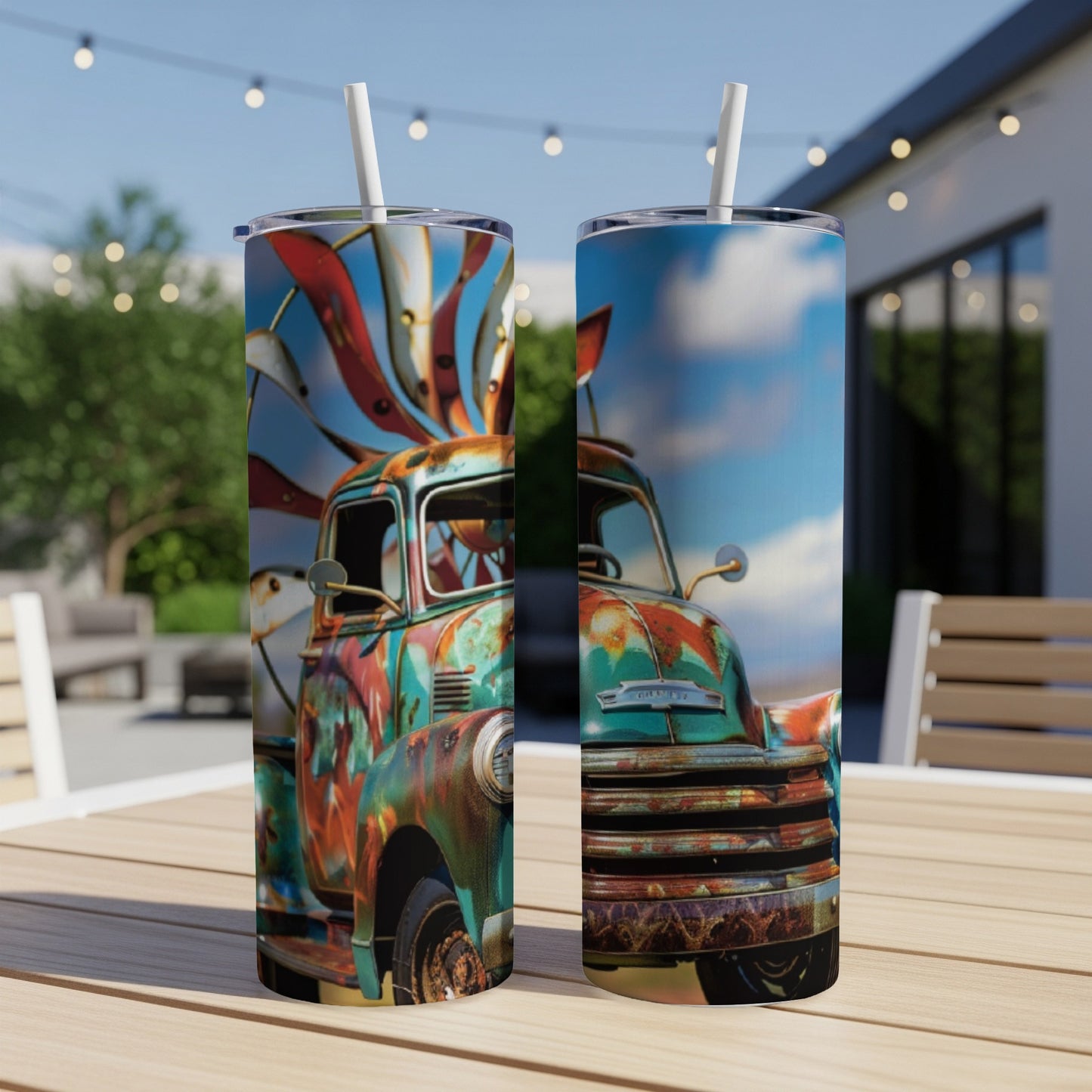 Two tumblers with rusted truck graphic sit on a wooden table outdoors.