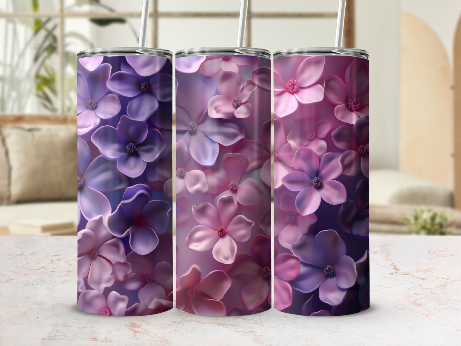 Three tumblers with a purple and pink floral pattern on a marbled surface.