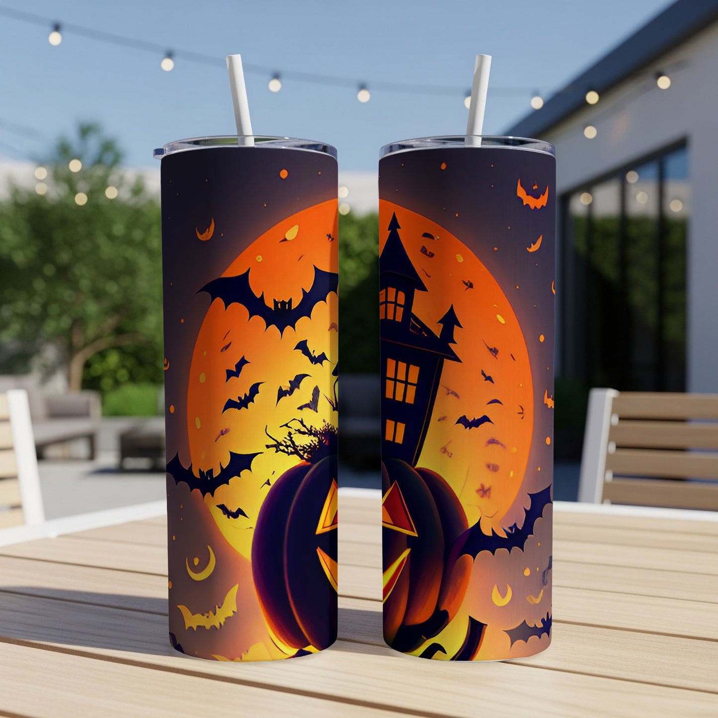 Two tumblers with a Halloween design featuring pumpkins, a haunted house, and bats against an orange moon.