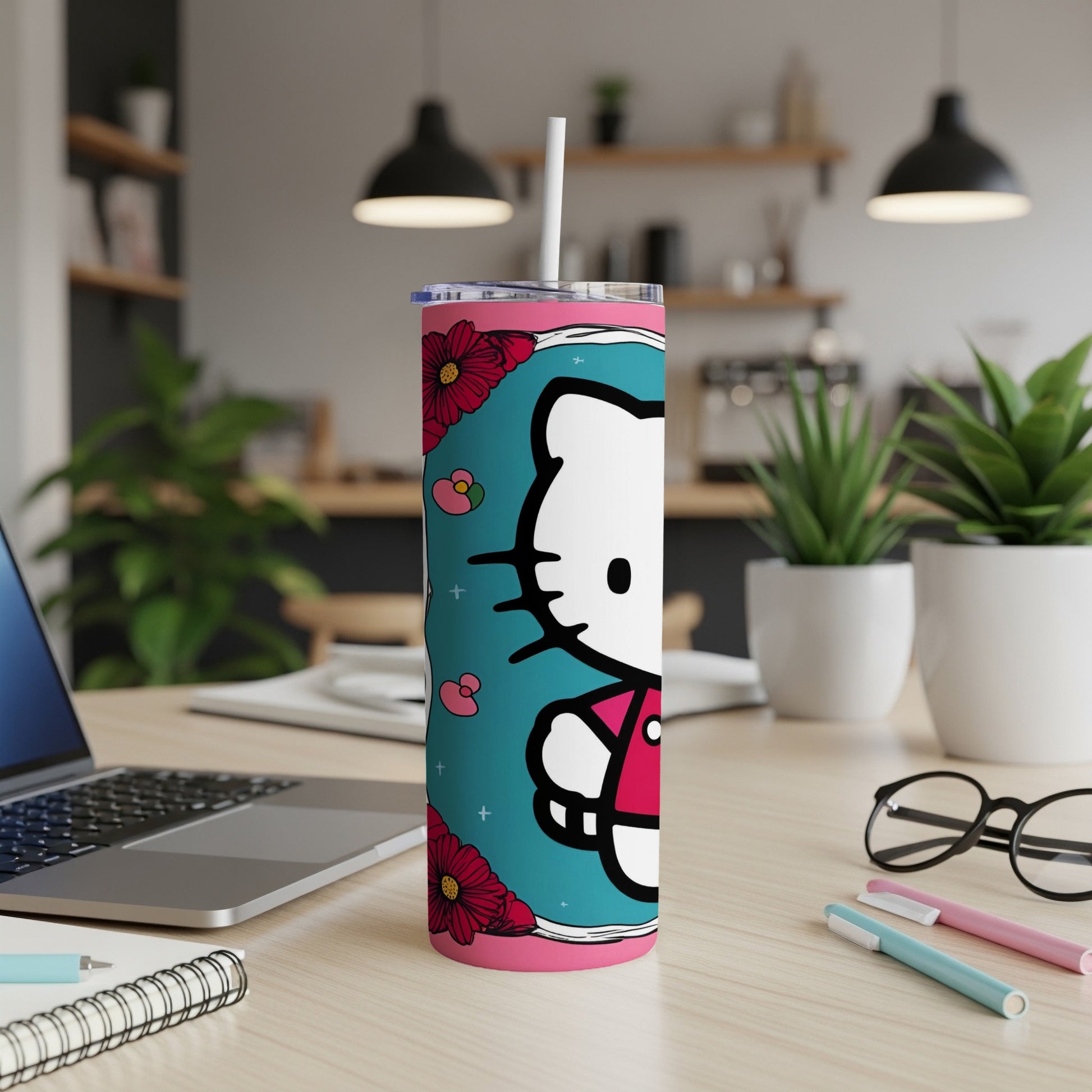 Hello Kitty tumbler with flowers and a straw on a desk.