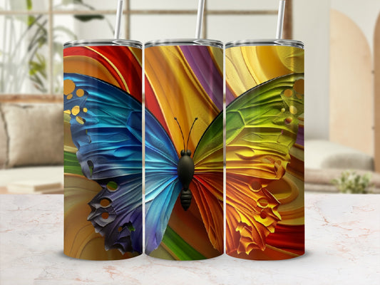 Three tumblers with colorful butterfly wing designs and straws.