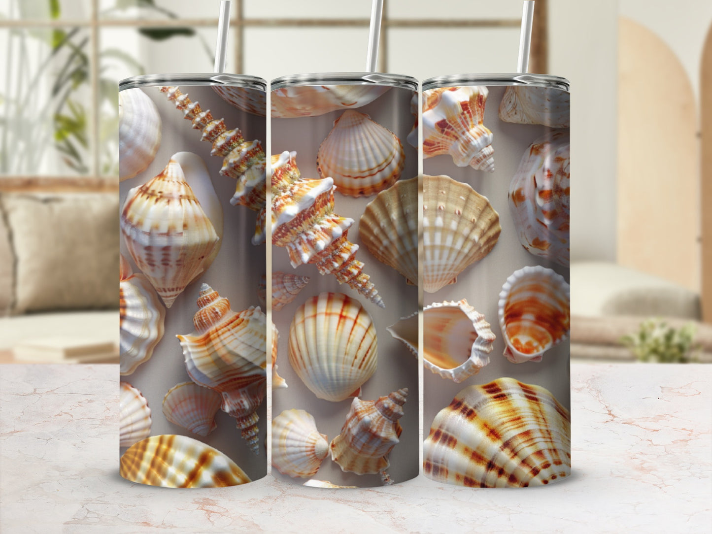 Three tumblers with seashell patterns on a marble countertop.