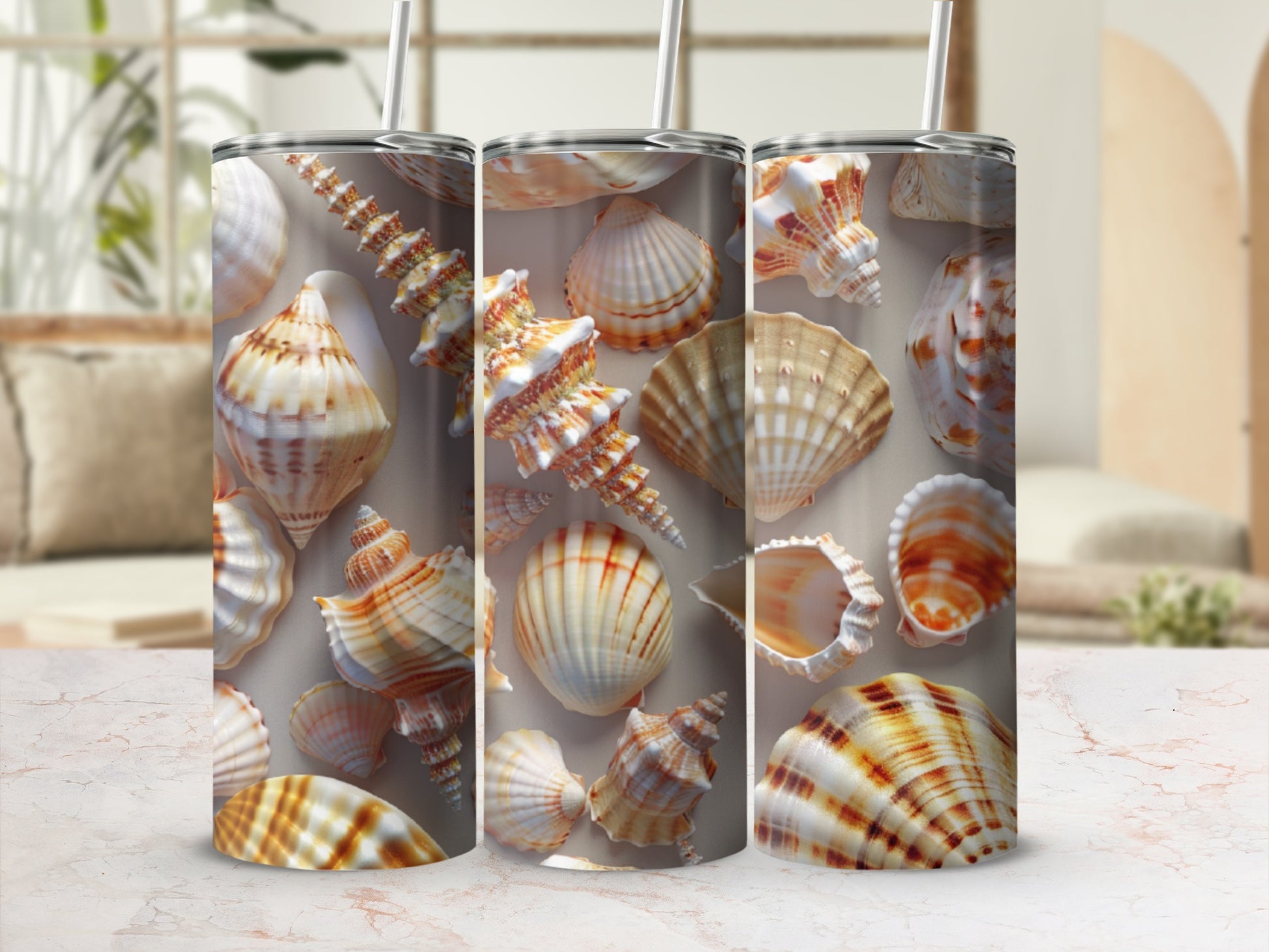 Three tumblers with seashell patterns on a marble countertop.