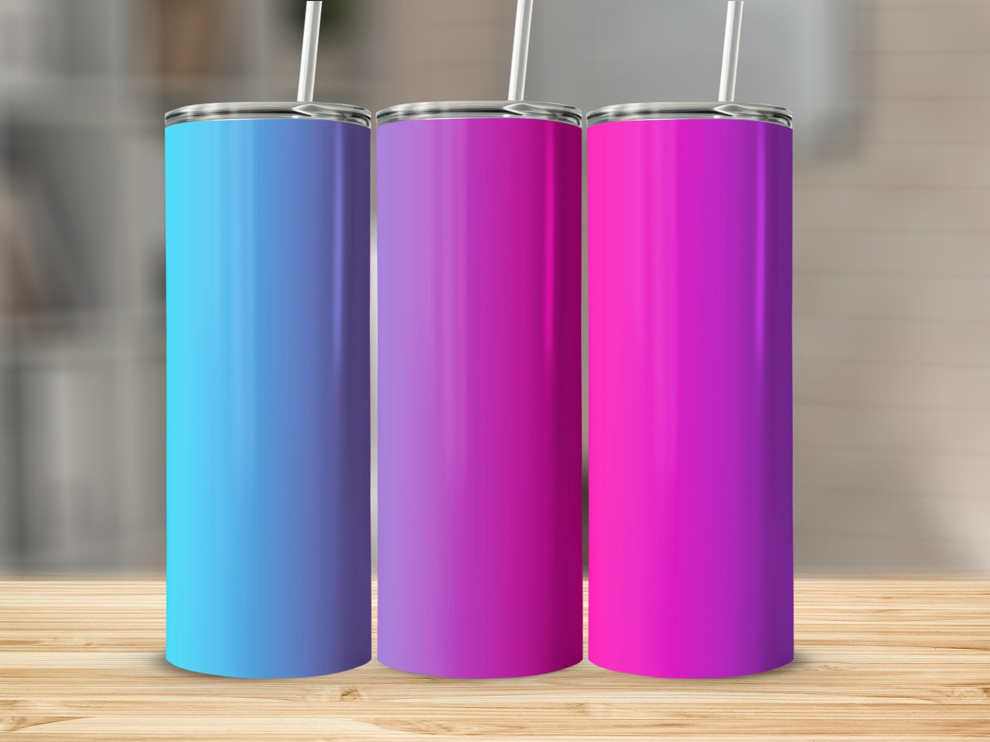 Three tall, slim tumblers in blue, purple, and pink with straws on a wooden surface.