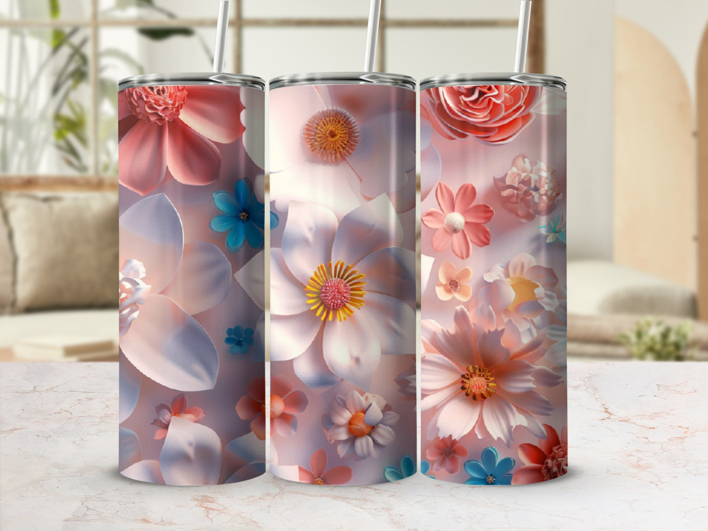 Three tumblers with floral designs and straws, set against a blurred background.