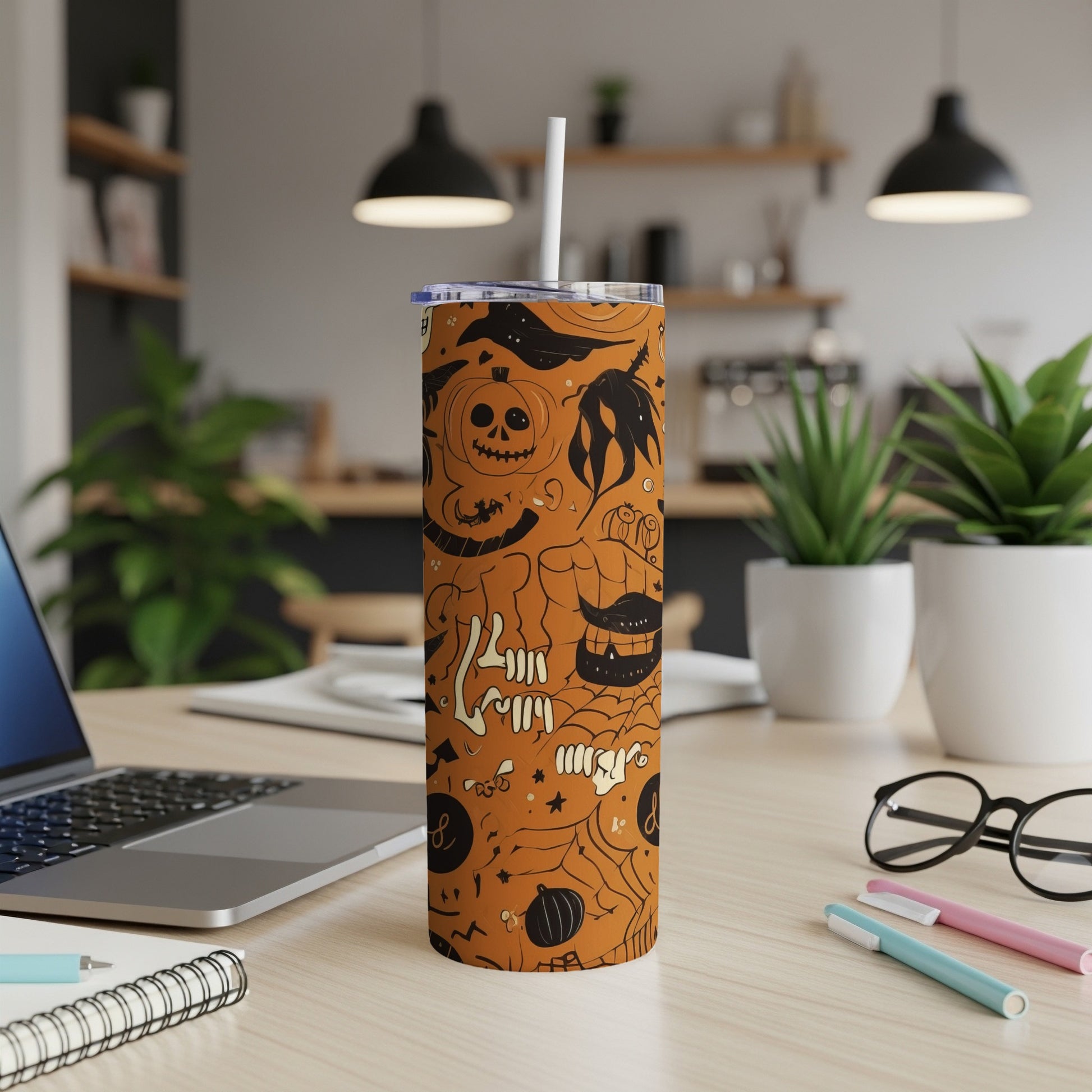 Orange tumbler with Halloween doodles, including pumpkins, skulls, and bats.