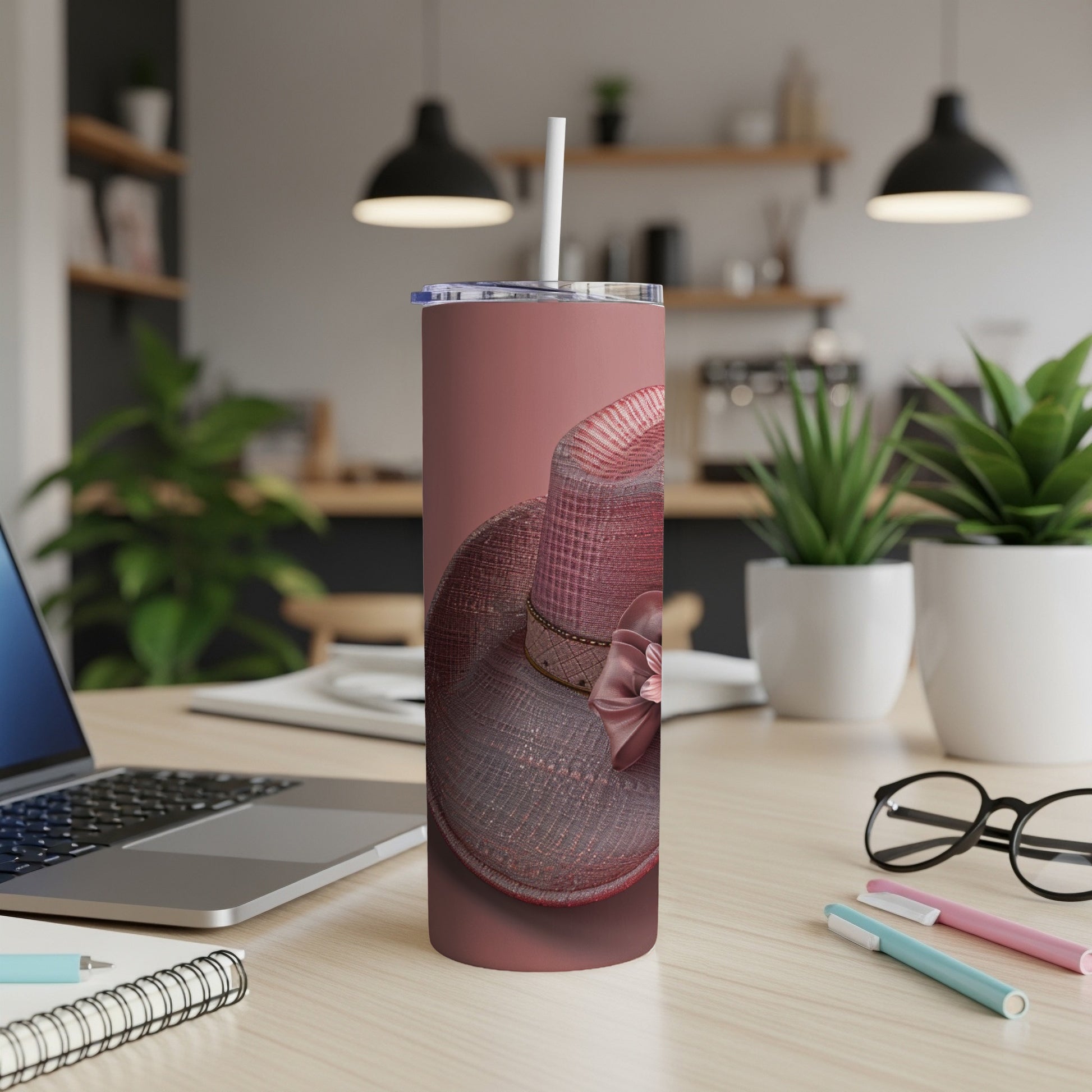 Rose gold tumbler with woven pattern and pink bow, on a desk.