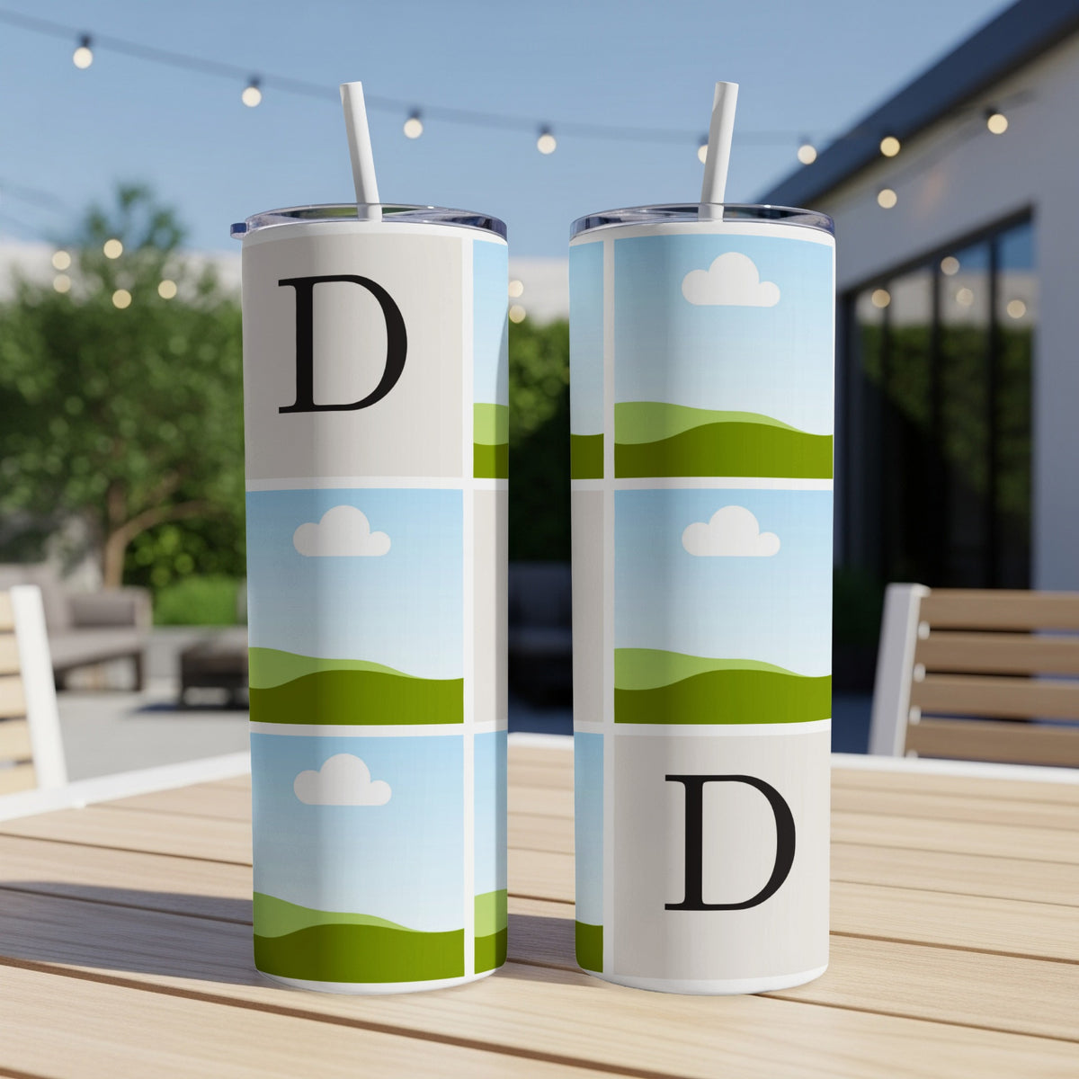 Two tumblers with a collage of sky, clouds, and rolling green hills, each featuring a large black letter D.