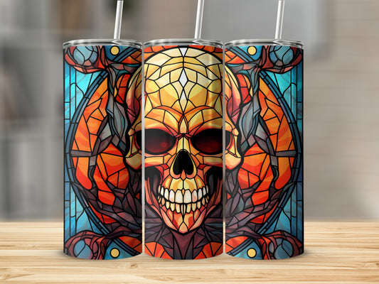Stained glass skull design on three cylindrical tumblers on a wooden surface.