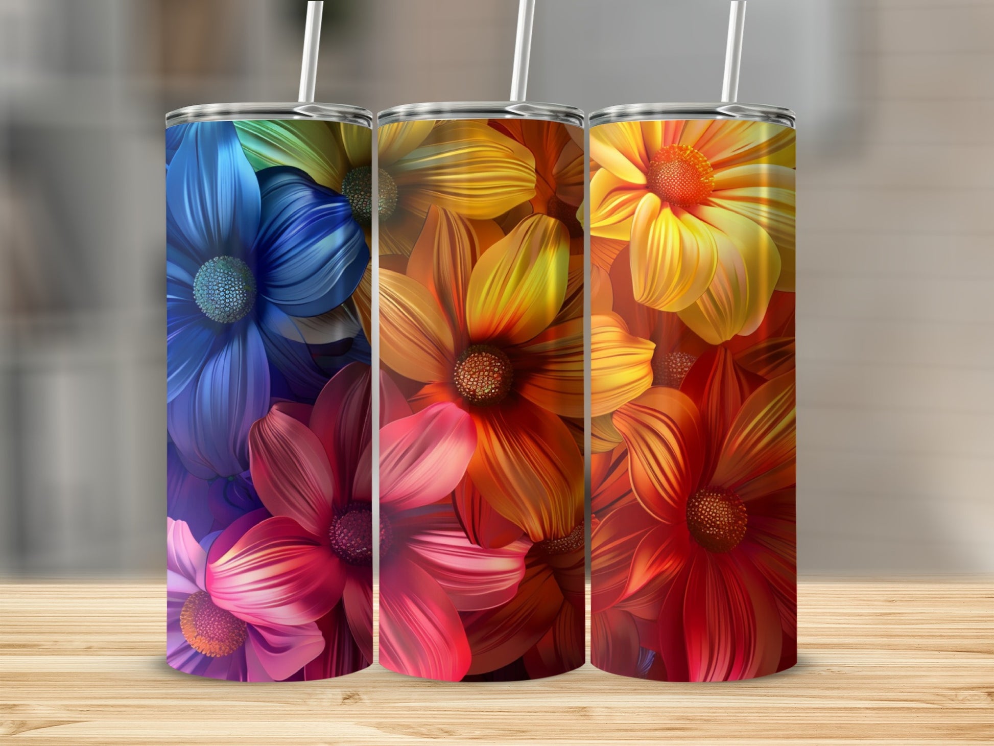 Three tumblers with colorful floral designs featuring red, orange, yellow, and blue petals.