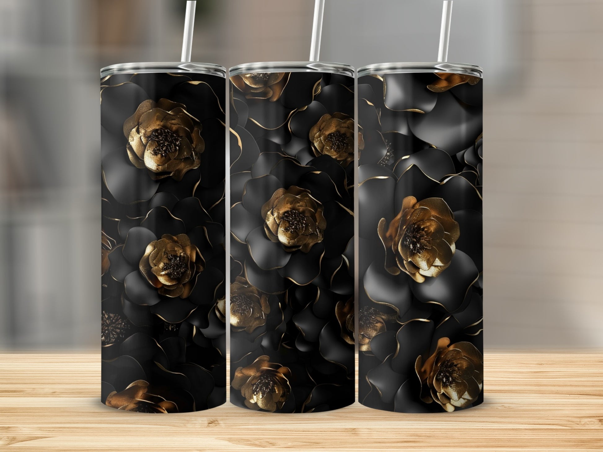 Three tumblers with black and gold floral design on a wooden surface.