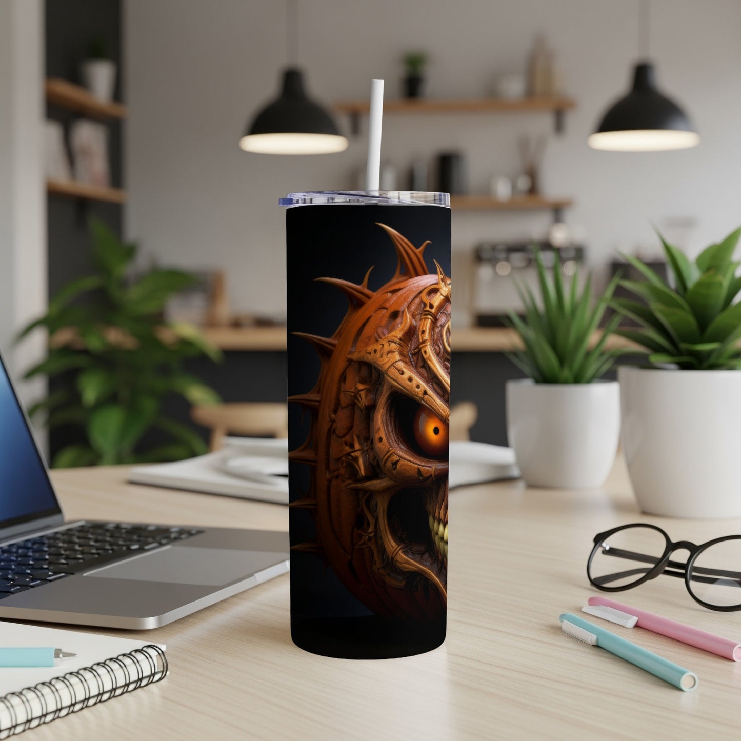 Tumbler with a creepy, spiky pumpkin skull design and an orange glowing eye.