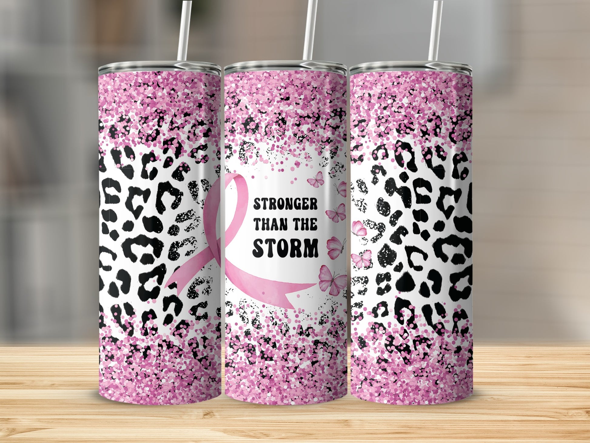 Pink glitter leopard print tumbler with "Stronger Than The Storm" text and ribbon.