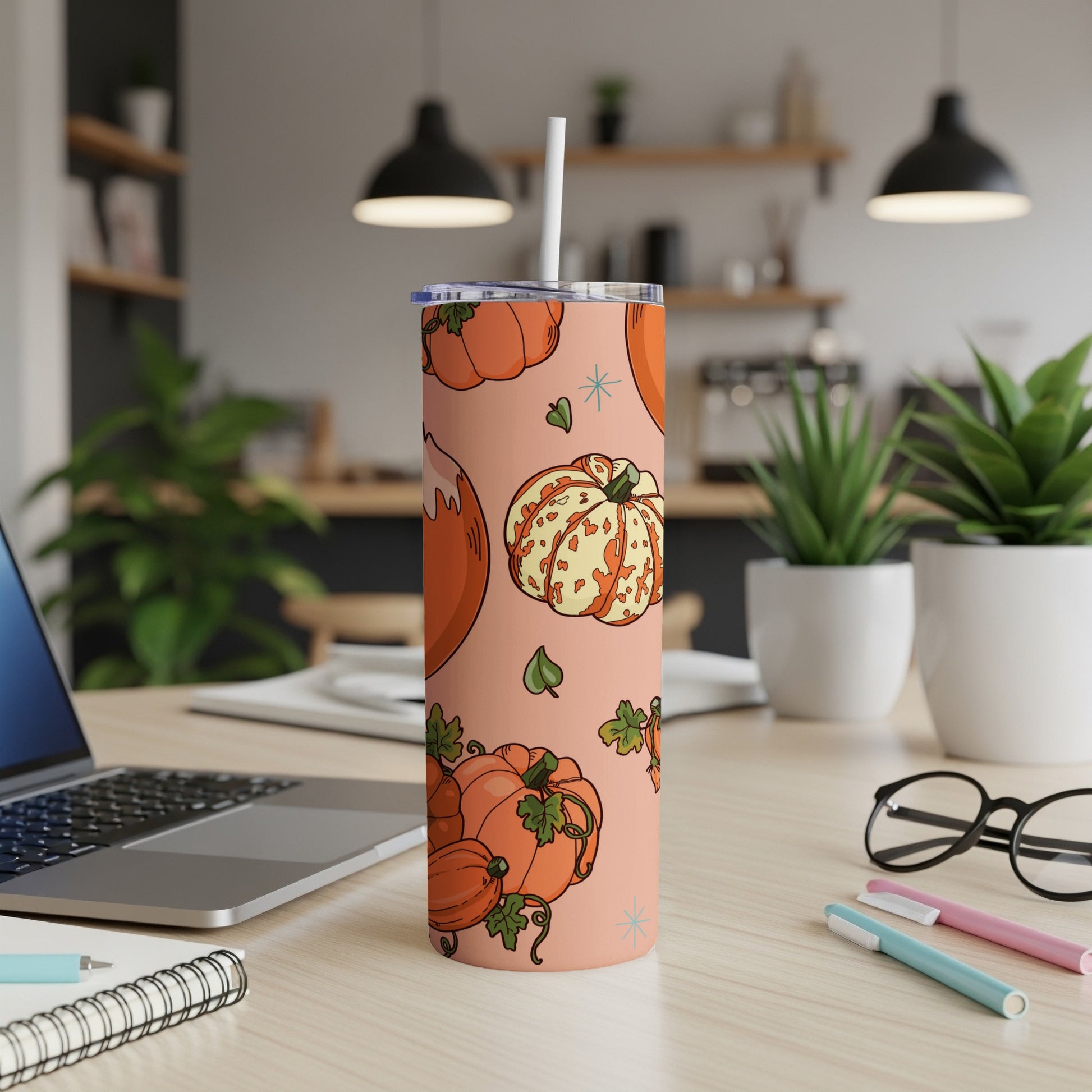 Pink tumbler with orange pumpkins and leaves pattern.