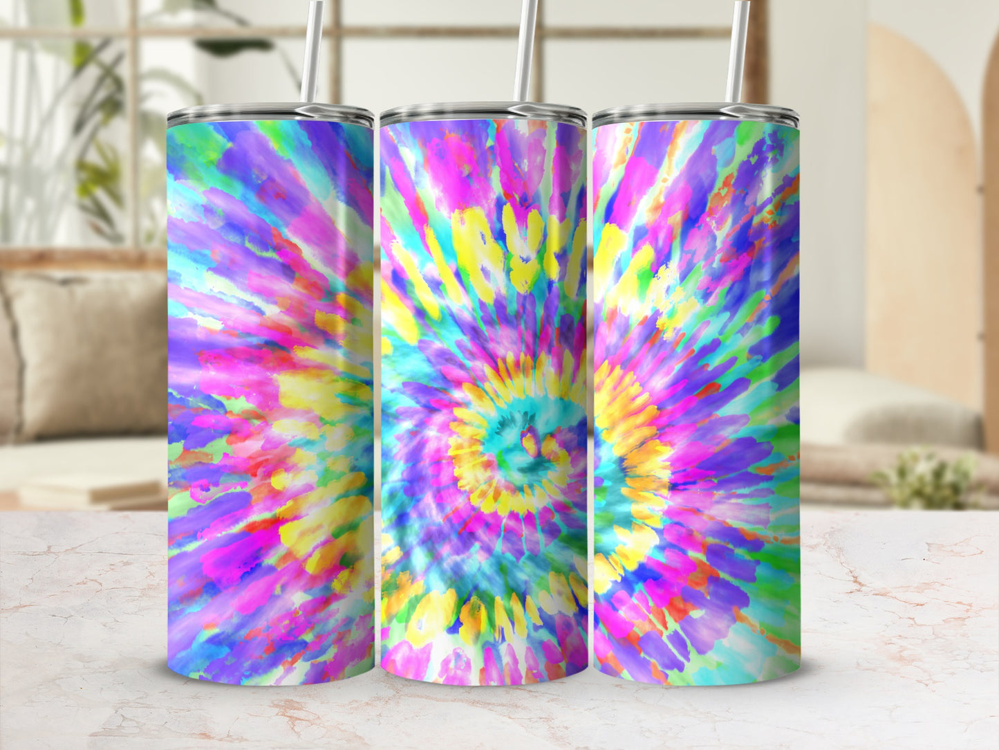 Three tumblers with a vibrant, colorful tie-dye pattern and metal straws.