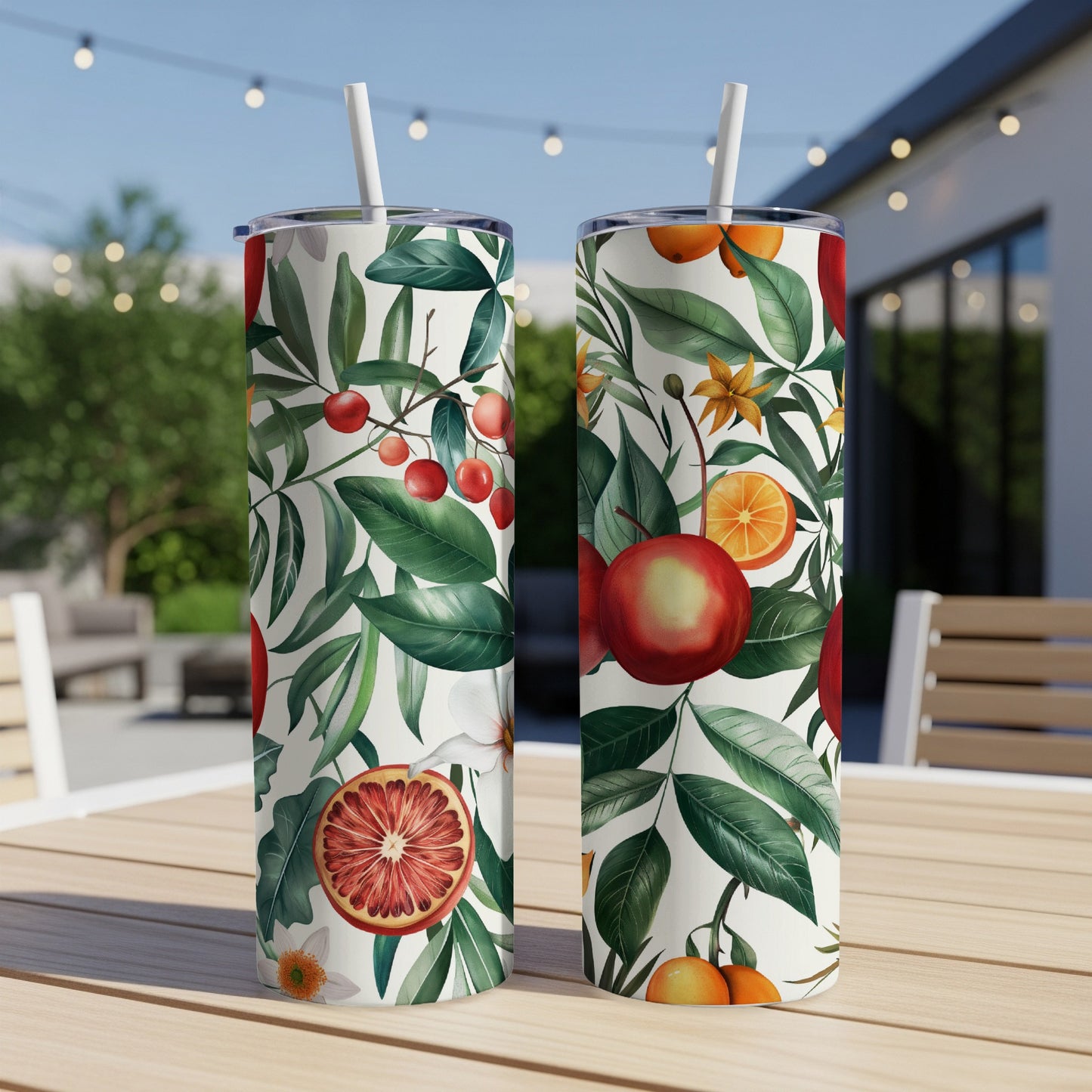 Two tumblers with a fruit and leaf pattern on a wooden table.
