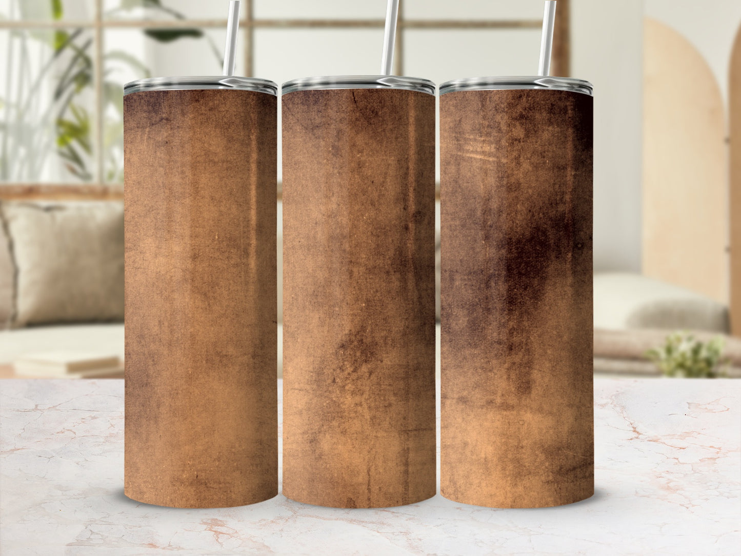 Three tumblers with a textured brown design stand on a marble surface.