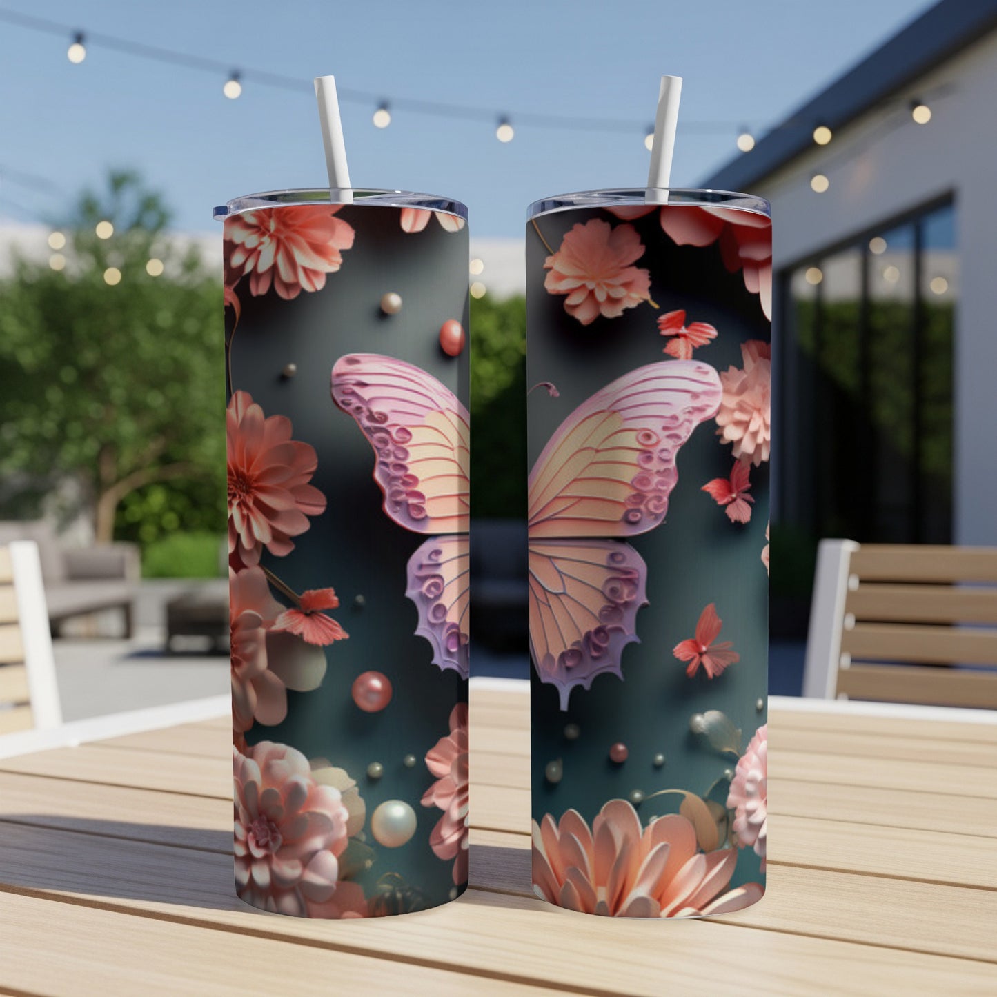 Two tumblers with a pink butterfly and floral design on an outdoor table.