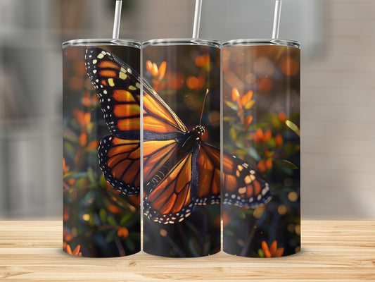 Three tumblers with a monarch butterfly design on a blurred floral background.