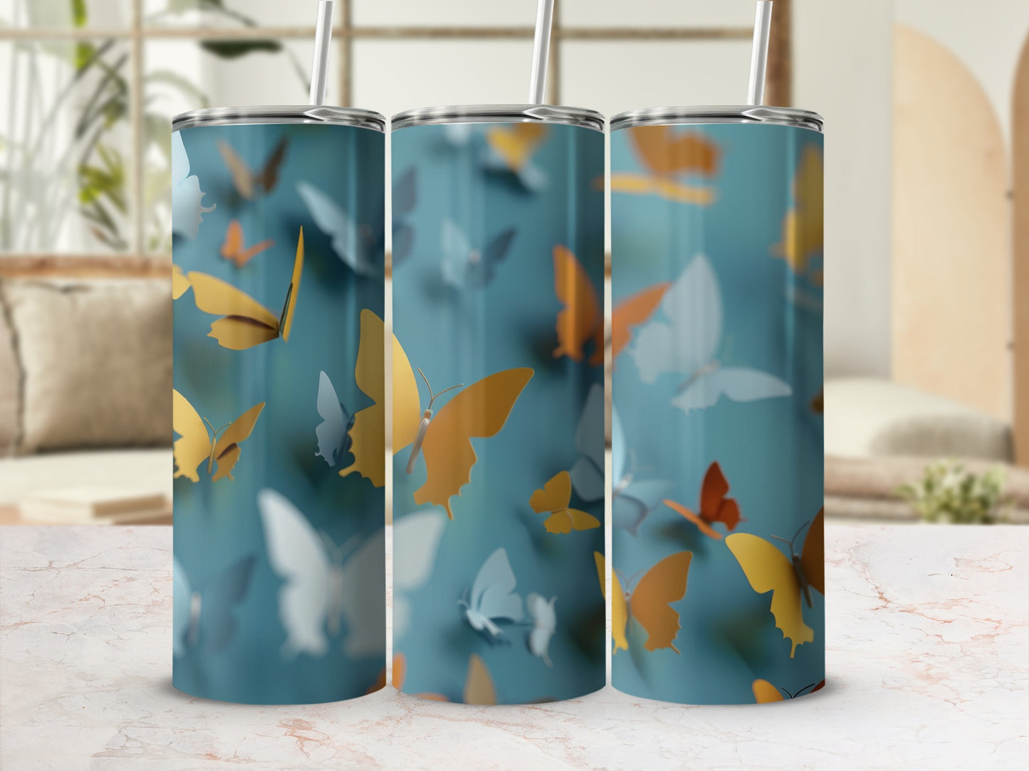 Three tumblers with orange and blue butterflies against a blurred background.