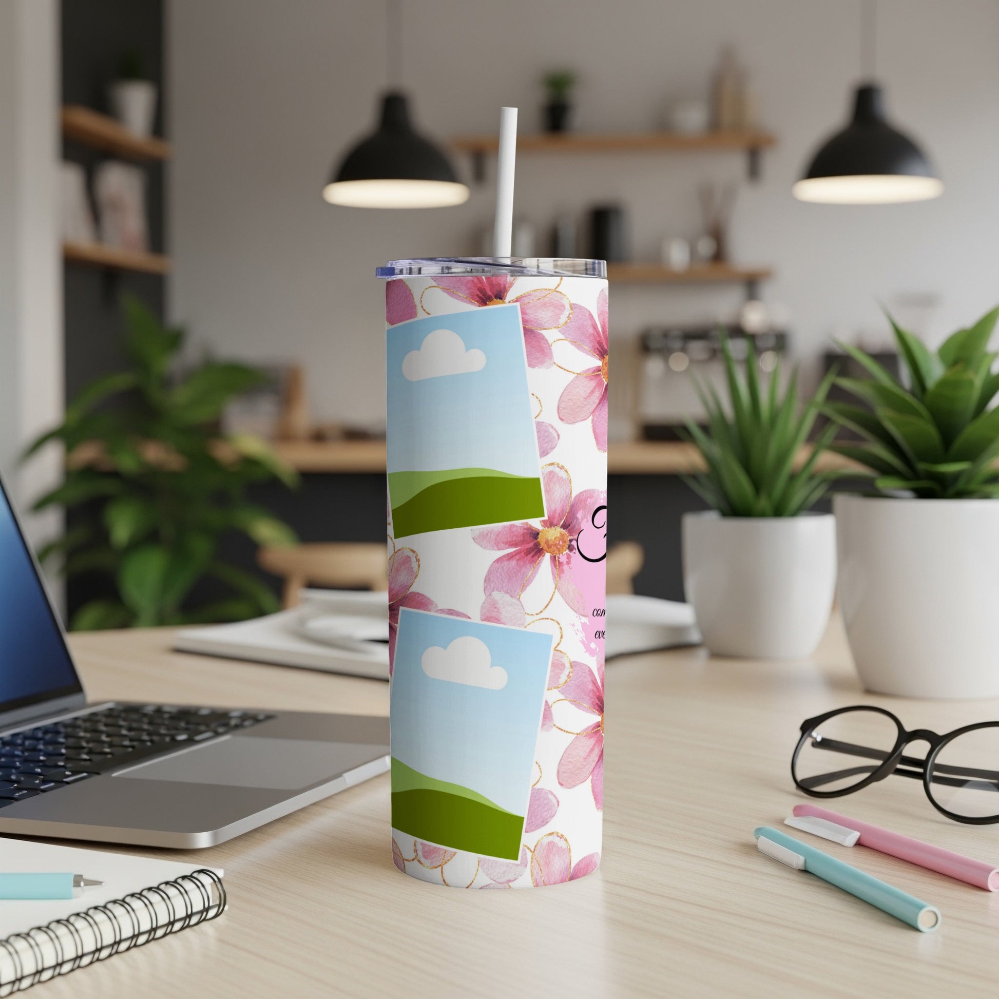 Tumbler with pink flowers, photo placeholders, and a straw on a desk.