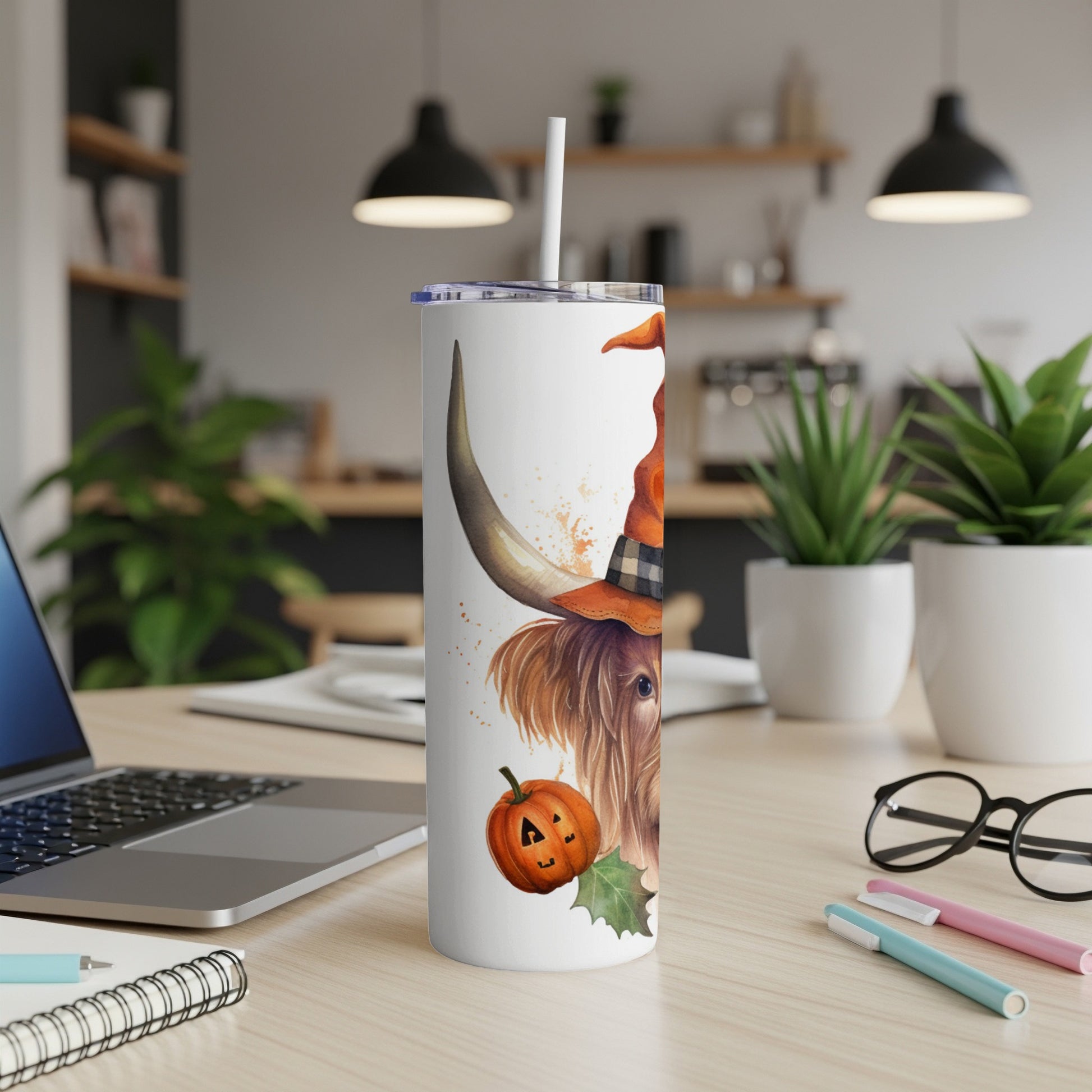 Highland cow wearing a witch hat with pumpkin and holly on a tumbler.